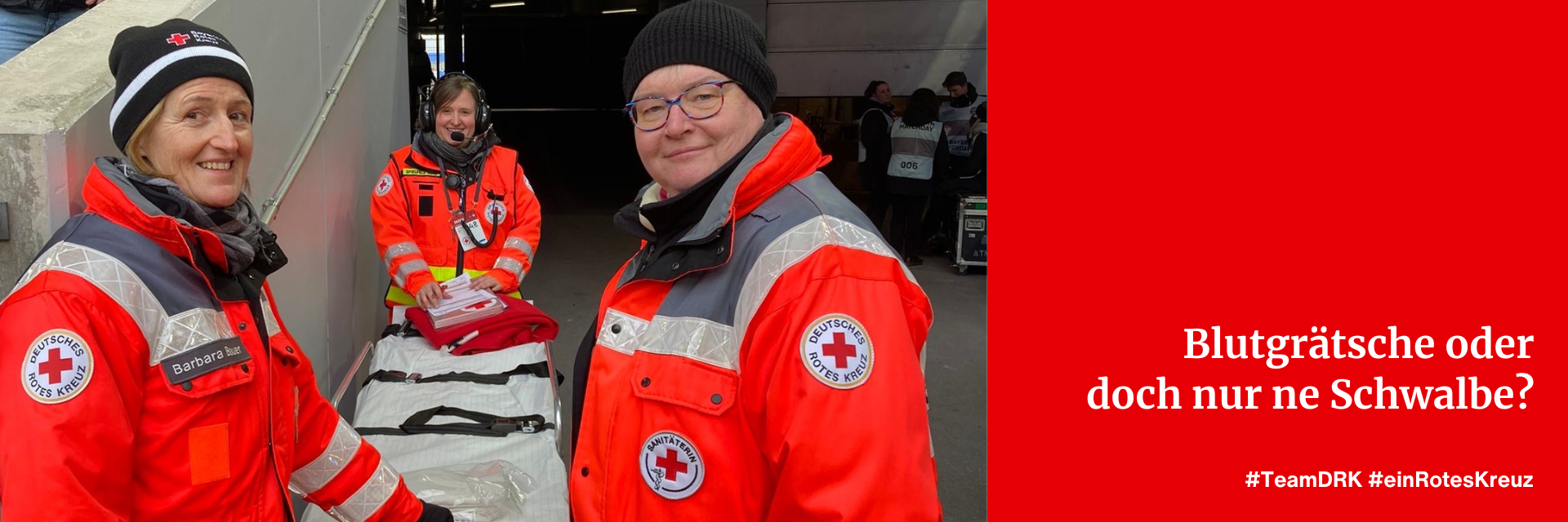Drei weibliche Einsatzkräfte des Deutschen Roten Kreuz stehen um eine Sanitätsliege.