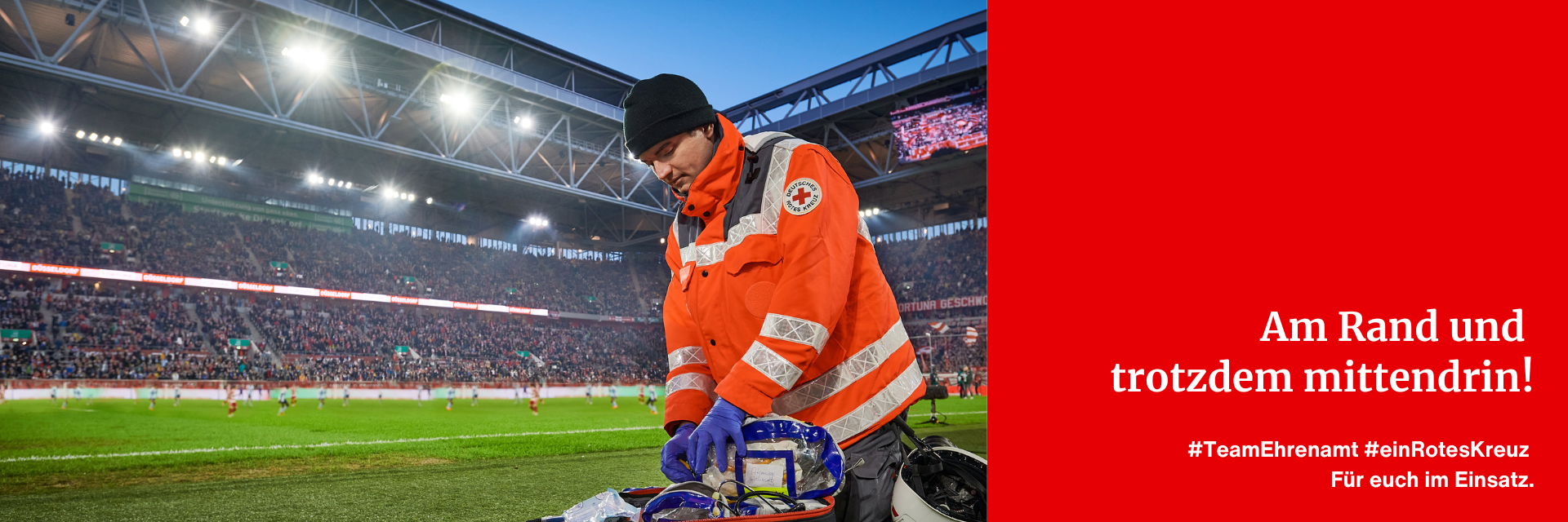 Eine männliche Einsatzkraft des Deutschen Roten Kreuz kontrolliert den Inhalt eines Sanitätsrucksacks in einem Fußballstadion.